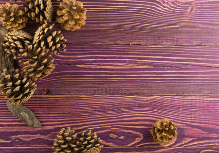 Brown pine cones on old rustic wood background. Beautiful nature pinecone christmas texture flat lay and top view with copyspaceの写真素材