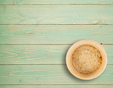 Heap of Bread Crumbs in Wooden Bowl Top View. Crushed Rusk Bread Crumbs or Panko on Wood Tableの写真素材