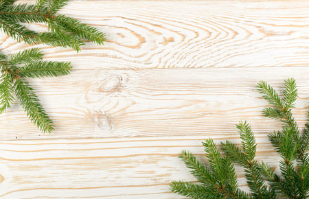 Christmas background with fir branches on wooden backdrop flat lay and top view. Yuletide floral...