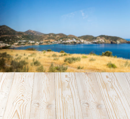 Wood table outside with seaview in beautiful summer day. Rustic wooden desk outdoor on sea view background. Template mock up with countertop for product advertisingの写真素材