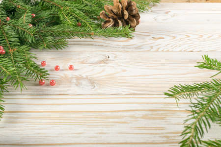 Christmas background with fir branches on wooden backdrop flat lay and top view. Yuletide floral frame decoration with copy space. Creative xmas tree border for New Year greeting cardの写真素材