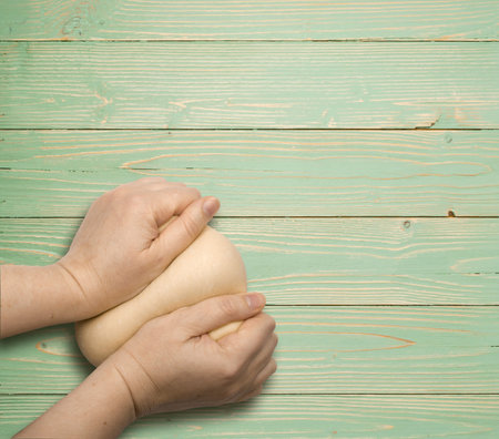Making Dough by Hands on Natural Wood Background Top View with Place for Text. Empty Wooden Desk Top for Product Advertisingの写真素材