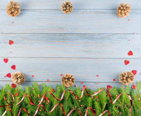 Blue Christmas background with fir branches on wooden backdrop flat lay and top view. Yuletide...