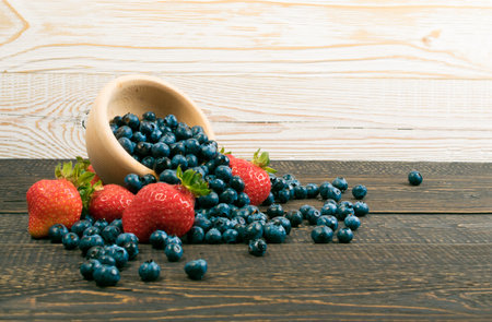 Fresh Beautiful Strawberries and Blueberries on Old Vintage Wooden Background with Copyspace. Dark...