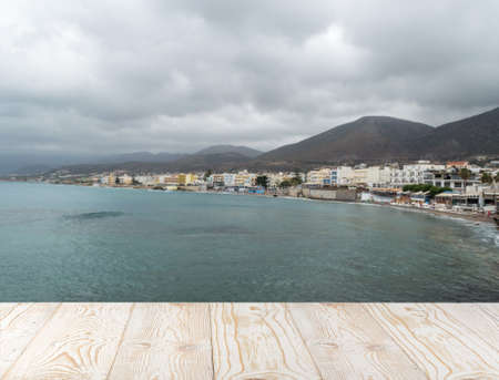 Wood table outside with seaview in beautiful summer day. Rustic wooden desk outdoor on sea view background. Template mock up with countertop for product advertisingの写真素材