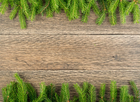 Christmas background with fir branches on wooden backdrop flat lay and top view. Yuletide floral...
