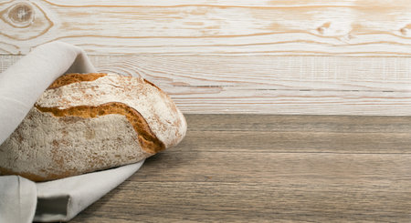 Homemade Freshly Baked Traditional Bread on Dark Wooden Table Top View with Copyspace. Whole Loaf of...
