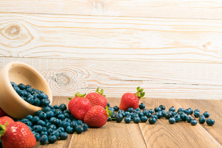 Fresh Beautiful Strawberries and Blueberries on Old Vintage Wooden Background with Copyspace. Dark...