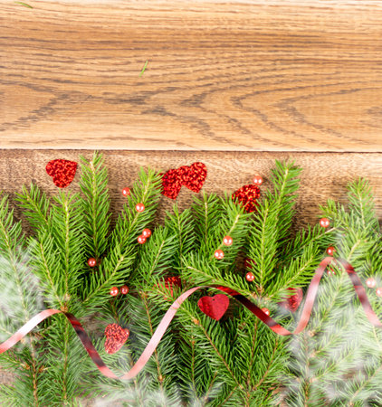 Christmas background with fir branches on wooden backdrop flat lay and top view. Yuletide floral...