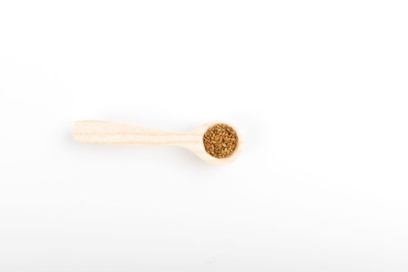 Alfalfa Seeds or Medicago in Wooden Spoon Isolated on White Background Top View. Small Lucerne...