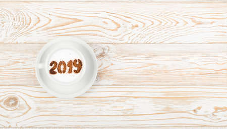 New Year Numbers 2019 on Macchiato or Latte Cappuccino. Hot Coffee Cup with Cream Milk Foam and Picture on a Festive Themeの写真素材
