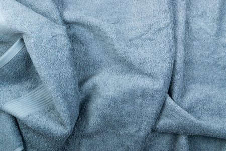 Gray hotel towel wave texture or material close up. New terry cotton towels or soft washcloth...