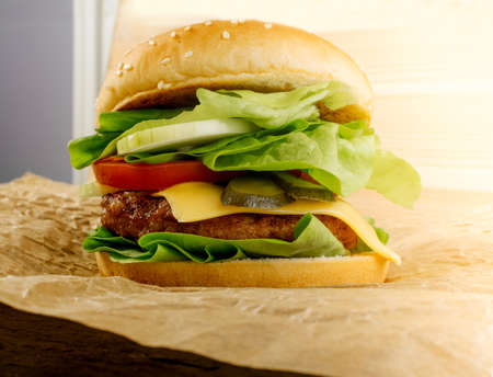 Classic Roast Beef Burger with Fresh Onions, Tomatoes, Green Lettuce Salad and Juicy Cutlet. Beefburger with Medium Rare Steak on Kraft Paperの写真素材