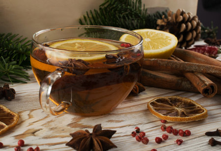 Winter drink with spices on festive new year background. Hot Christmas tea with cinnamon, red...
