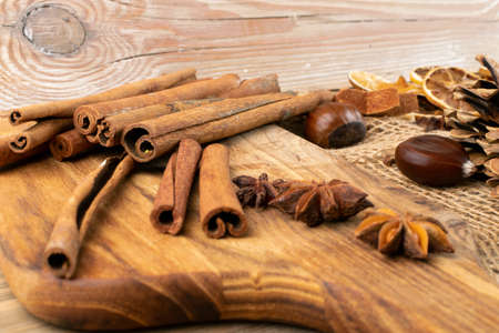 Brown autumn still life with chestnuts, cinnamon sticks, dried lemons and pine cones top view and flat layの写真素材