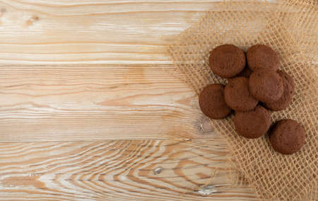 Heap of soft homemade chocolate butter cookie with chocolate filling on rustic table background. Brown round soft biscuits or small fresh round cocoa pies closeup and top viewの写真素材