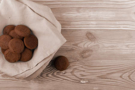 Heap of soft homemade chocolate butter cookie with chocolate filling on rustic table background. Brown round soft biscuits or small fresh round cocoa pies closeup and top viewの写真素材