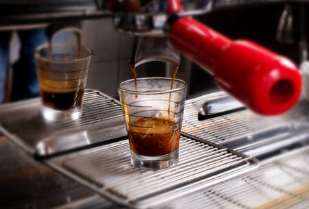 Macro shot of preparing espresso on professional coffee machine. Making coffee in espresso shot in coffeeshop or cafe closeupの写真素材