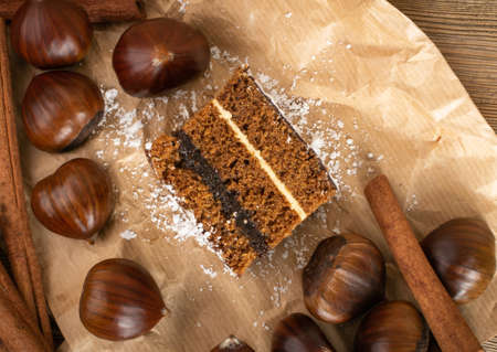 Homemade chestnut cake desert or sponge cake with spices on kraft paper. Rectangular piece of brown cocoa tart, gingerbread or layer biscuitの写真素材