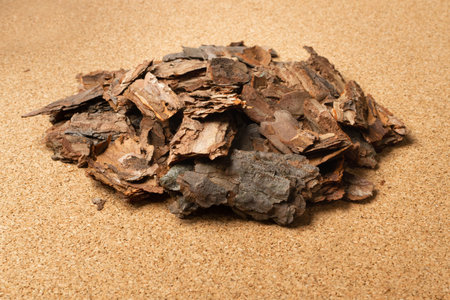 Heap of Dry Pine Tree Bark Pieces on Brown Cork Board Background. Broken Woods Nature Chip on Cork...