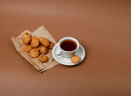 Natural baked coconut cookies or coconut macaroons with tea or coffee. Homemade diet biscuits with coco chips on brown paper backgroundの写真素材