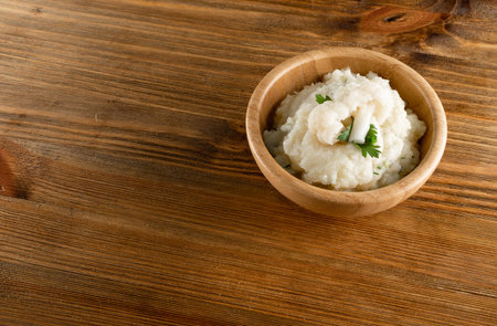 Homemade cauliflower puree in wood bowl closeup, healthy diet vegetable food. Irish colcannon with mashed cabbage, potato and greens on wooden rustic table backgroundの写真素材