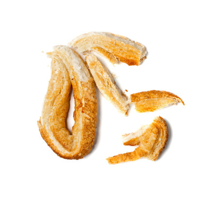 Piece of palmiers pastry, palm heart or elephant ear isolated on white background. French puff...