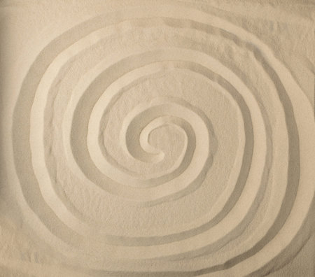 Drawing of the sun on light beige sea sand texture. Sun print on sandy beach background, solar drawn...