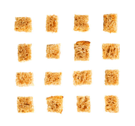 Set of homemade rye bread croutons isolated on white background top view. Crispy bread cubes collection, dry rye crumbs, rusks, crouoton or brown roasted crackers cube patternの写真素材