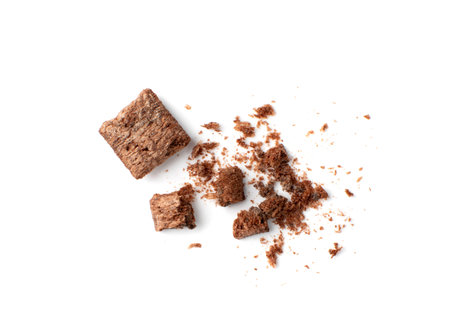 Crumbled chocolate pillows for breakfast isolated on white background. Broken choco cereal pads with cream, crispy corn flakes, healthy sweet snackの写真素材