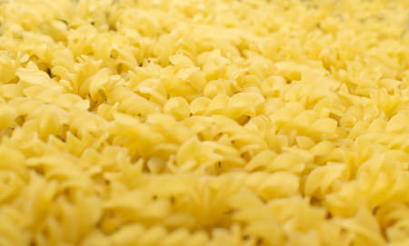 Macro Photo of Raw Italian Fusilli Texture Background. Egg Fusillo Pasta Pattern. Dry Short Eliche Macarons or Rotini Wallpaper Top Viewの写真素材