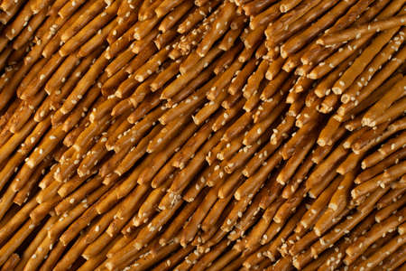 Salt sticks texture background with copy space. Salty pretzel sticks flat lay pattern, grissini wallpaper or thin breadsticks mockupの写真素材
