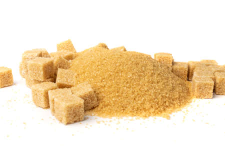 Brown sugar sand and cubes isolated on white background. Pile of raw unrefined cane sugar heap side viewの写真素材