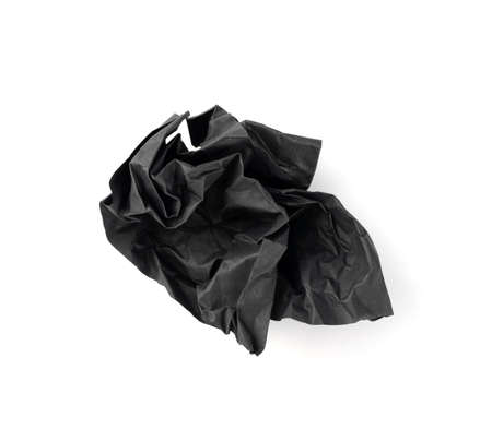Crumpled Black Paper Ball Isolated on White background. Natural Textured Wadded Up Scrunched Sheet. Crumpled up dark paper ballの写真素材