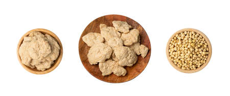 Raw dehydrated soy meat or soya chunks collection in wood bowls isolated top view. Texturized vegetable protein or TSPの写真素材