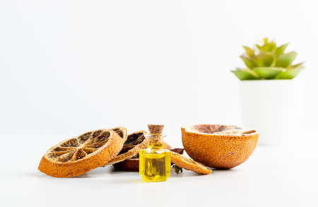 Dry orange peel essential oil in small vintage bottle. Zest organic oil in medicine jar. Essence, tincture, extract or infusion white background closeupの写真素材