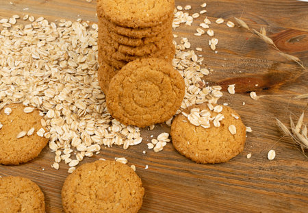 Thin oatmeal cookies or healthy cereal oat crackers closeup. Crispy anzac biscuit cookie with oat...