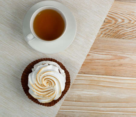 Big white meringue cookie mockup top view. Traditional homemade whisk merengues on wood background with copy space, baked whisking cream mock up or beze cooking recipe templateの写真素材