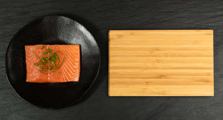 Slice of Raw Salmon Fillet on Black Background Mockup Top View. Thick Piece of Fresh Red Fish or Trout with Copy Spaceの写真素材
