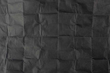 Folded Crumpled Black Paper Texture Background. Dark Wrinkled Rolling Paper Sheet Pattern with Copy Space. Creased Crimson Page Wallpaperの写真素材