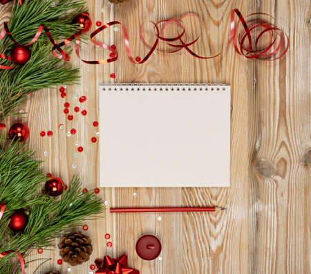 Christmas Decorations Mockup with White Notepad Top View. Blank Sheet with Red Pencil for Wish List or Xmas Greeting Card with Copy Spaceの写真素材