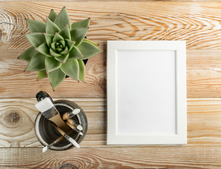 Minimal artist mockup with brushes on wood table flat lay and top view. White paper mock up...