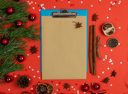 Christmas Decorations Mockup with Blank Sheet Top View. Red Xmas Background with Copy Spaceの写真素材