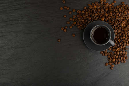 Top view espresso cup and coffee beans on black stone background with copy space. White coffeecup or mug with hot beverageの写真素材