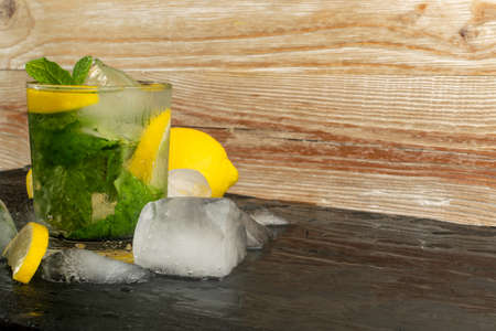 Cold mint julep, iced lemon drink with copy space. Sweet green tea with ice, lemon and fresh mintの写真素材