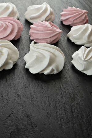 White and pink meringue cookies closeup. Traditional whisk merengues, baked whisking cream or beze on blurred backgroundの写真素材