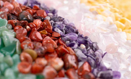 Colorful stones texture background. Green, red, blue, white, black and purple quartz pebbles mix top viewの写真素材