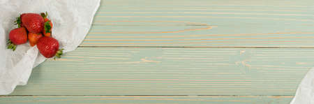 Fresh Beautiful Strawberry on Old Vintage Wooden Background and Paper with Copyspace. Blue Wood Table Desk Board Texture with Ripe Berry Top Viewの写真素材