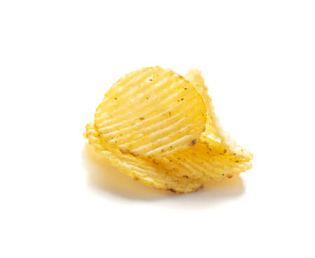 Corrugated chips isolated on white background, wavy potato chips, crispy snack close up. Fluted crisps top viewの写真素材
