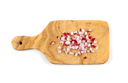 Chopped radis roots on cutting board isolated. Fresh radish root cuts, pile of diced red radishes on white backgroundの写真素材